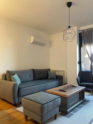 Moderan i svetao enterijer dnevne sobe u Apartmanu Luni u Kraljevu sa udobnim nameštajem i trpezarijskim stolom.